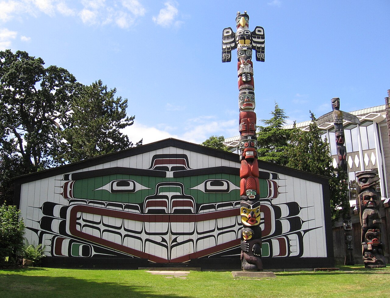 Mungo Martin House aka Wawadit'la (1953) en drie Kwakwaka'wakw totempalen uit – van links naar rechts – 1953, 1981, 1954.  