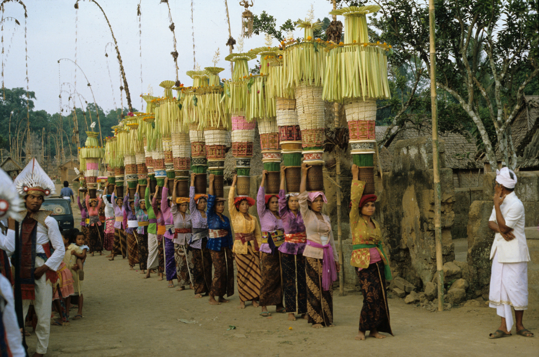 Een groep vrouwen uit dezelfde banjar (wijk) in Penglipuran (een dorp in centraal Bali), allen gekleed in een gekleurde kebaya en gebatikte kain, brengt familieoffers naar de tempel waar op die dag de stichtingsdag van de tempel wordt gevierd, 1 november 1982. (7358-39) © Francine Brinkgreve 