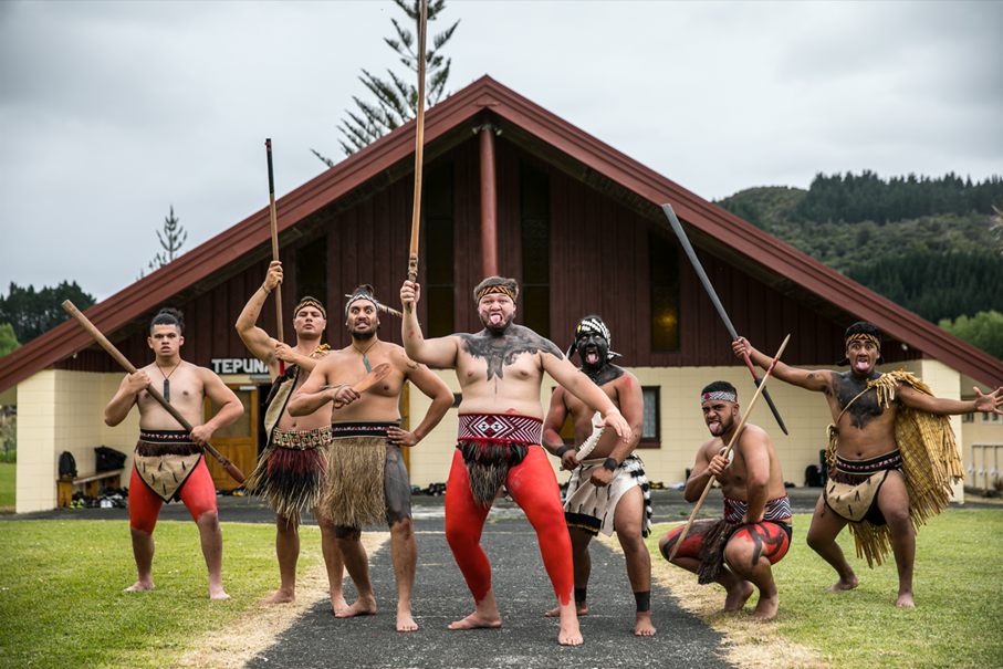 Māori men in front of the meeting house. The techniques of the martial art Māu rākau are taught there to the next generation. Photo Te Rawhitiroa