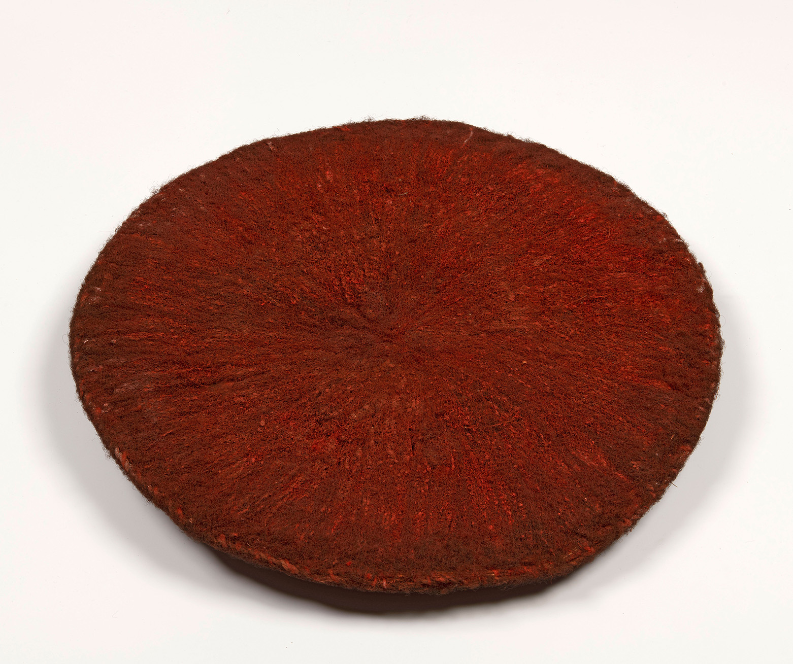 This isicholo is made with human hair, an unknown fibre and dyed with ochre. RV-5647