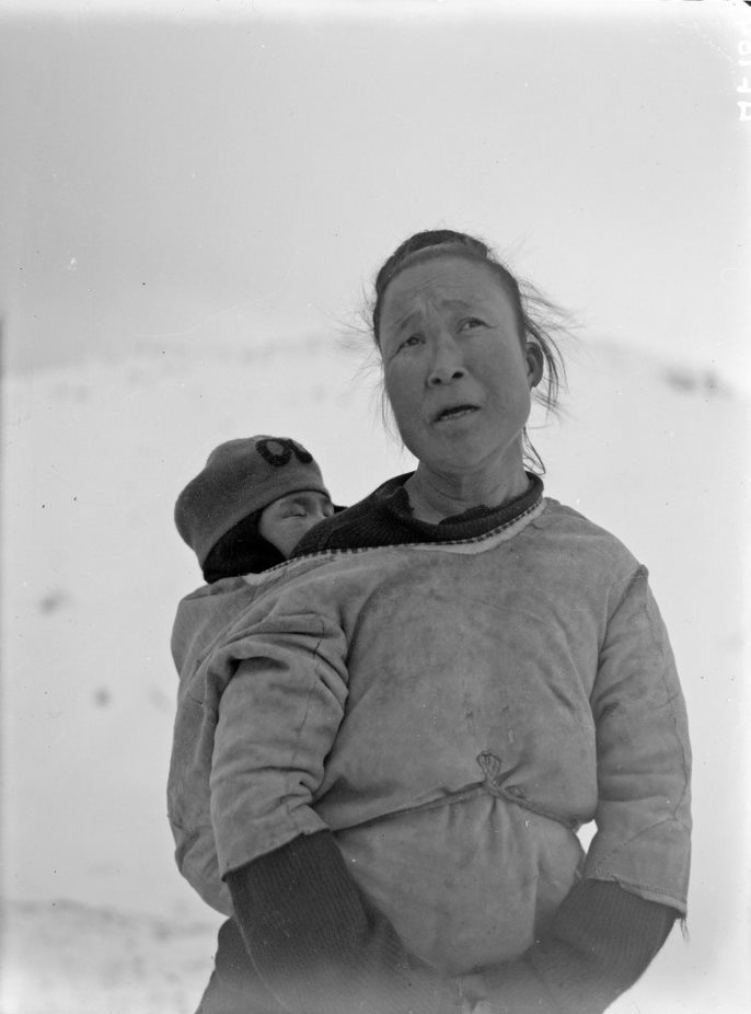 Gundine in Oost-Groenland draagt een amaut met kind op de rug