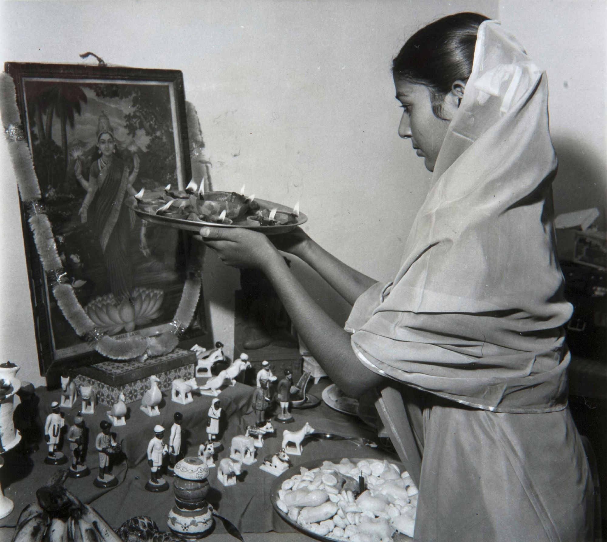 Een vrouw voert de Diwali puja uit. India. Foto: Press Information Bureau, 1950-1960. (TM-60060444)