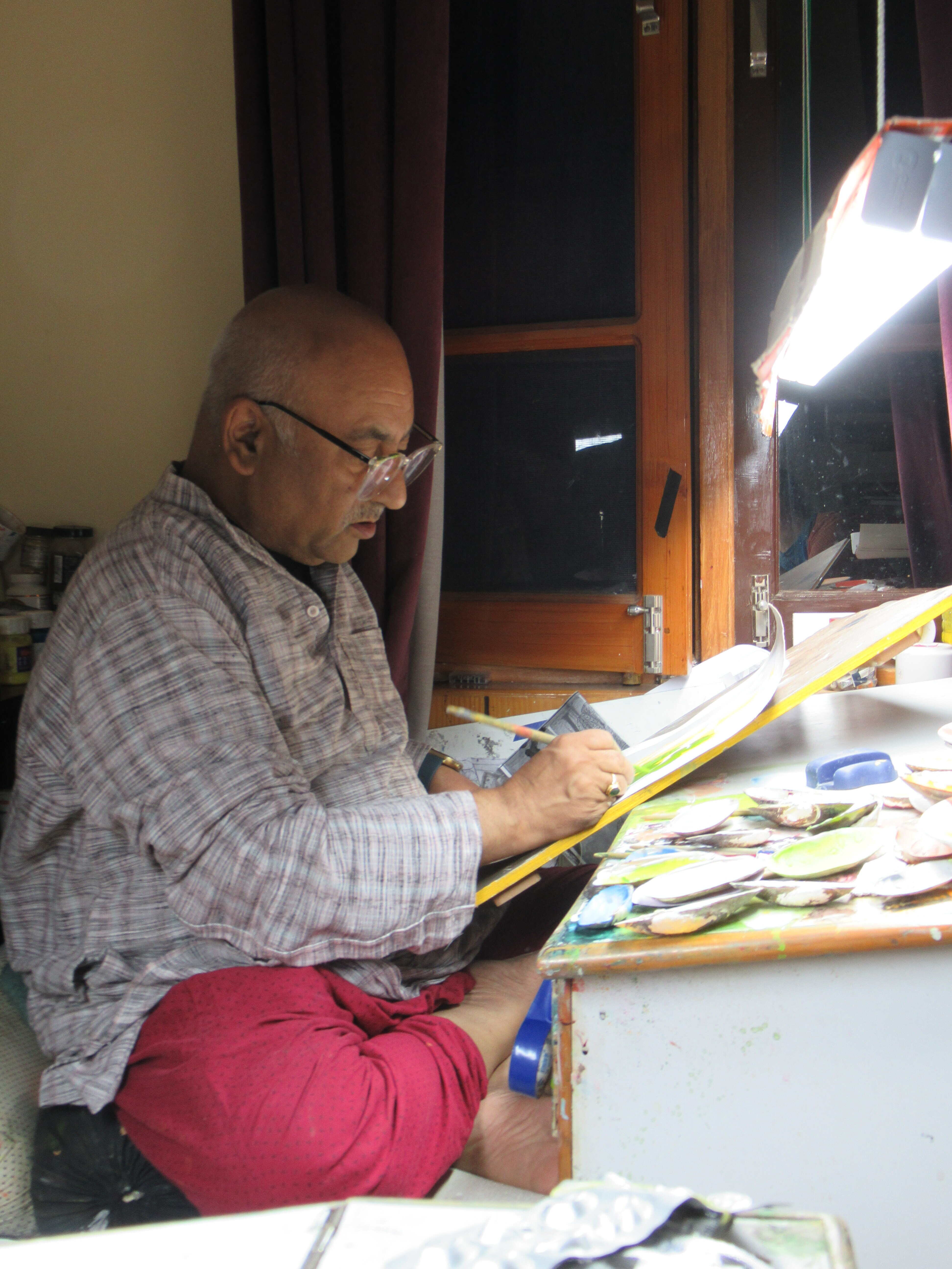 Vijay Sharma's schildersmateriaal, privé studio, Chamba (Himachal Pradesh). De schilder Padma Shri Vijay Sharma aan het werk. (© Amélie Couvrat Desvergnes, oktober 2022)