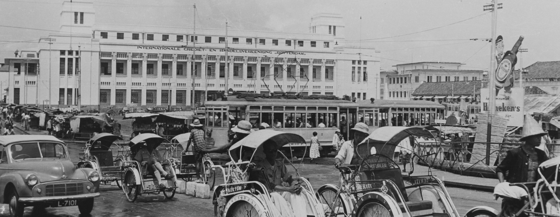 Bicycle taxis, cars and a tram at the intersection in front of the office of the International Credit and Trade Association "Rotterdam". Surabaya, between 1953 and 1960. Photo: NMVW Collection