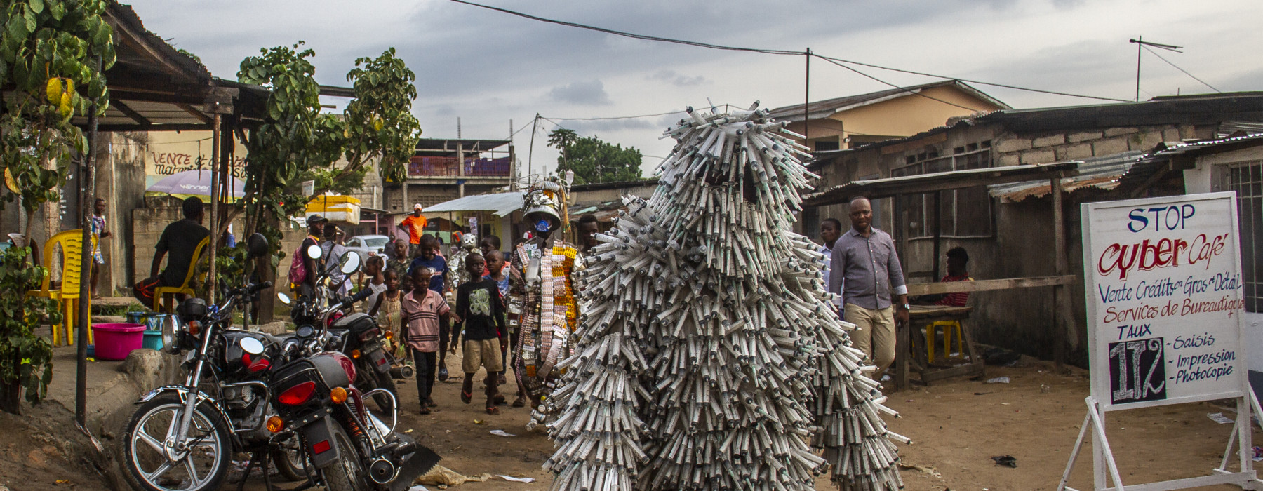 Flory Sinanduku performt SANTE PUBLIC, in plastic spuiten-pak in Kinshasa, Congo. Foto: Azgard Itambo