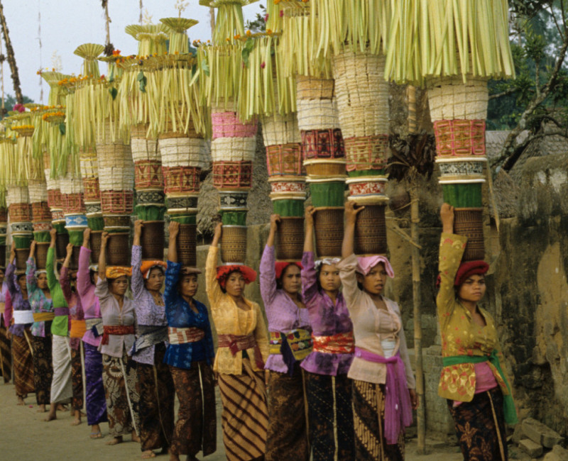Een groep vrouwen uit dezelfde banjar (wijk) in Penglipuran (een dorp in centraal Bali), allen gekleed in een gekleurde kebaya en gebatikte kain, brengt familieoffers naar de tempel waar op die dag de stichtingsdag van de tempel wordt gevierd, 1 november 1982. (7358-39) © Francine Brinkgreve