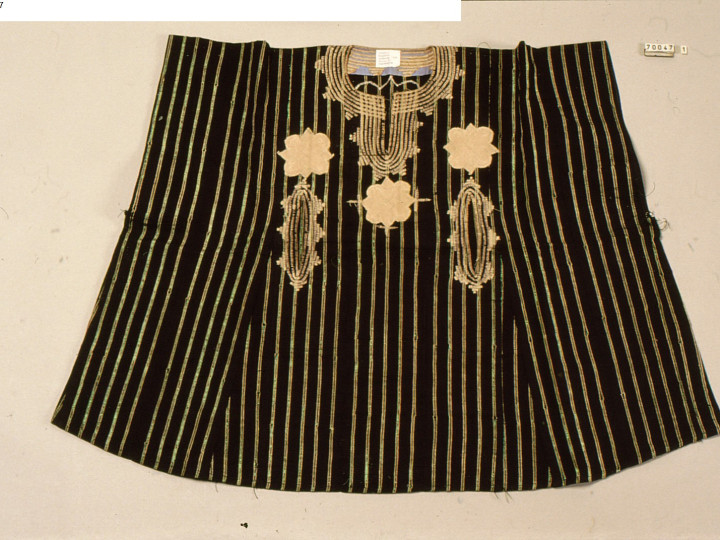 Zwarte boubou uit de jaren 1980, Nigeria, versierd met gouden verticale strepen. Op de voorkant zijn drie bloemachtige borduursels te zien. De zak van deze boubou is vrij uniek: hij zit lager op de voorkant en heeft twee openingen in plaats van de gebruikelijke één. (WM-70047)
