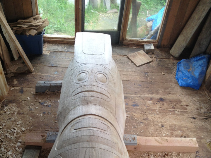 Houtsnijders snijden de basis van de totempaal in het U'mista Cultural Centre in Alert Bay in Canada. Het is ook een werkervaringsproject voor leden van de gemeenschap.